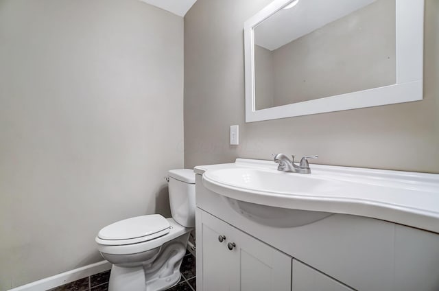 bathroom with tile patterned flooring, vanity, and toilet