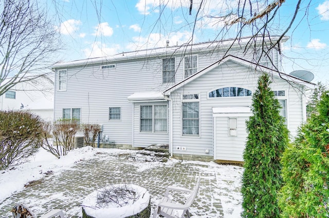 view of snow covered rear of property