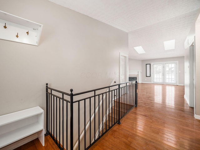 hallway featuring wood-type flooring and a skylight