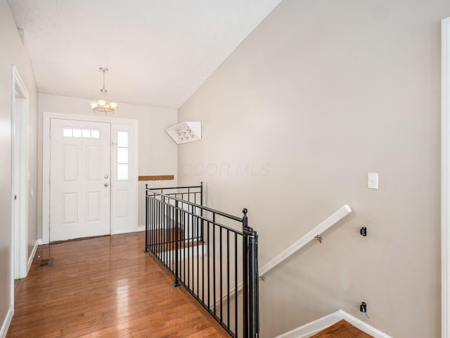 entryway featuring hardwood / wood-style flooring and an inviting chandelier