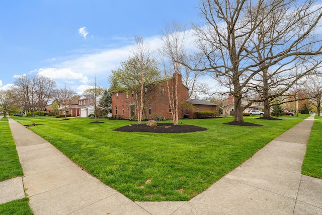 view of side of home featuring a residential view, brick siding, a chimney, and a lawn