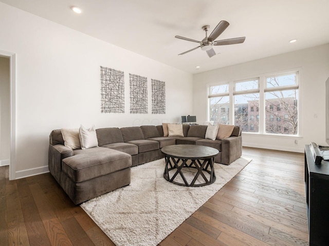 living room featuring ceiling fan and dark hardwood / wood-style flooring