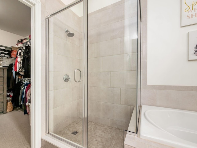 bathroom featuring shower with separate bathtub