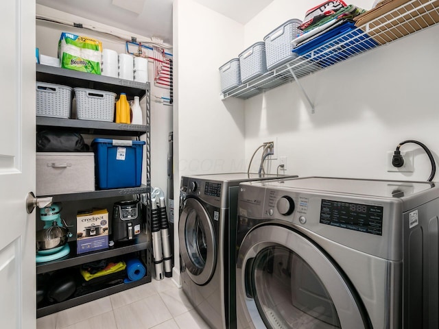 washroom with washer and clothes dryer and light tile patterned floors