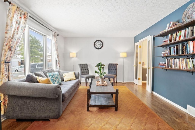 living room with hardwood / wood-style floors and a textured ceiling