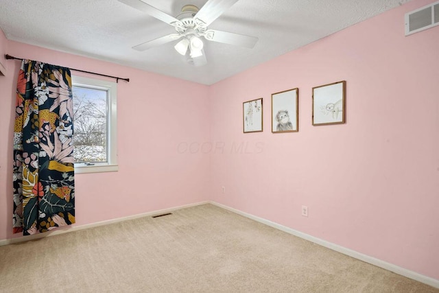 empty room featuring carpet, a textured ceiling, and ceiling fan