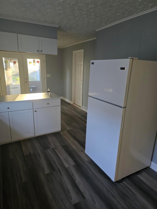 kitchen featuring ornamental molding, white refrigerator, french doors, dark wood-type flooring, and white cabinets