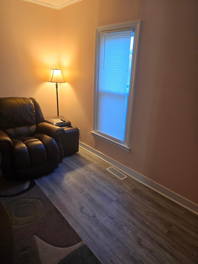 sitting room with hardwood / wood-style flooring and ornamental molding