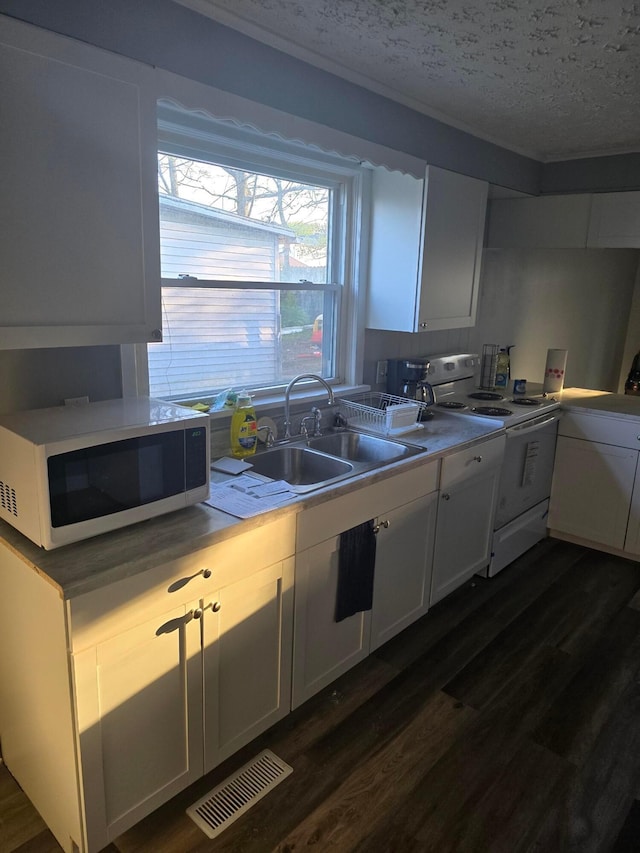 kitchen featuring white appliances, a textured ceiling, dark hardwood / wood-style floors, white cabinets, and sink