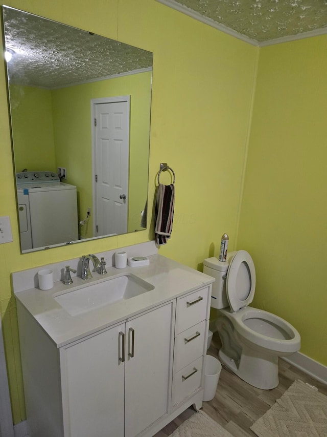 bathroom featuring independent washer and dryer, a textured ceiling, crown molding, wood-type flooring, and vanity