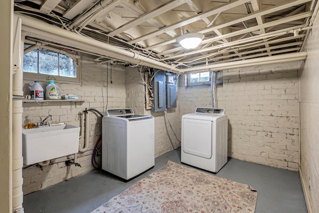 laundry area with electric panel, sink, and washer and dryer