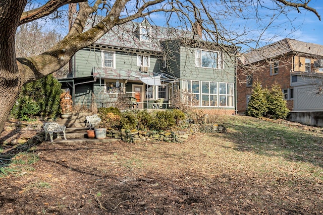 back of house featuring a yard and a sunroom