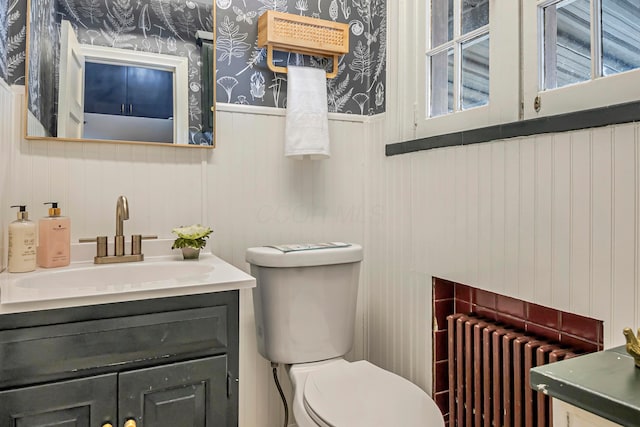 bathroom with vanity, radiator heating unit, and toilet