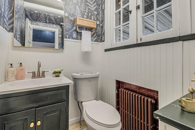 bathroom featuring vanity, toilet, and radiator