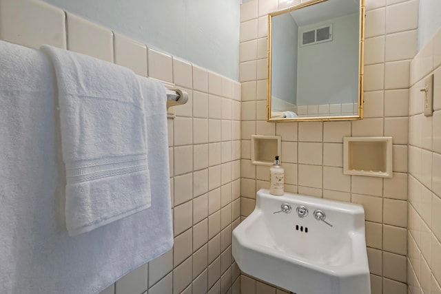 bathroom with sink and tile walls