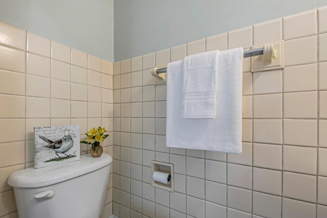 bathroom featuring tile walls and toilet