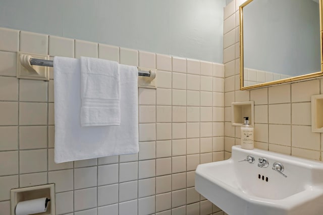 bathroom with sink and tile walls