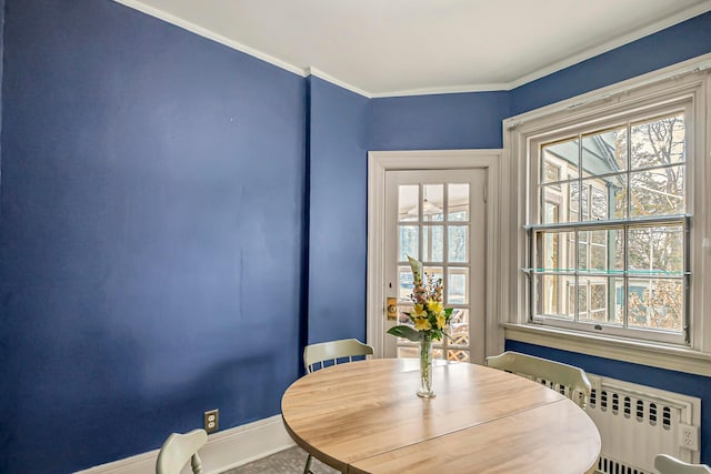 dining space with crown molding and radiator