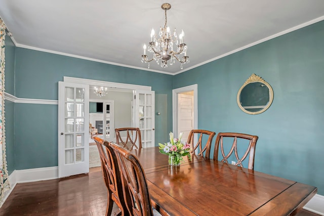 dining room featuring ornamental molding, dark wood-type flooring, a notable chandelier, and french doors