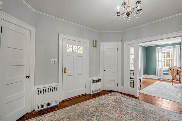 entrance foyer featuring hardwood / wood-style floors, radiator heating unit, and ornamental molding