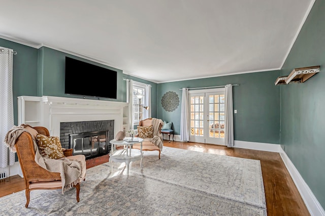 living room featuring crown molding, wood-type flooring, and french doors