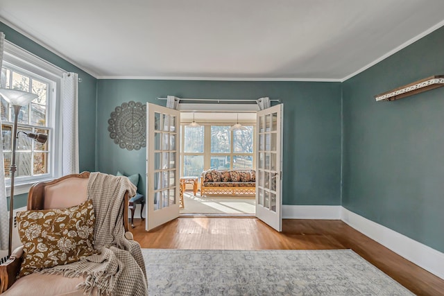 interior space with ornamental molding, hardwood / wood-style floors, and french doors