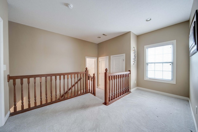 spare room featuring light carpet