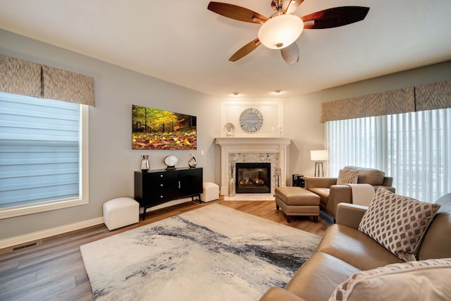 living room with ceiling fan, hardwood / wood-style floors, and a fireplace