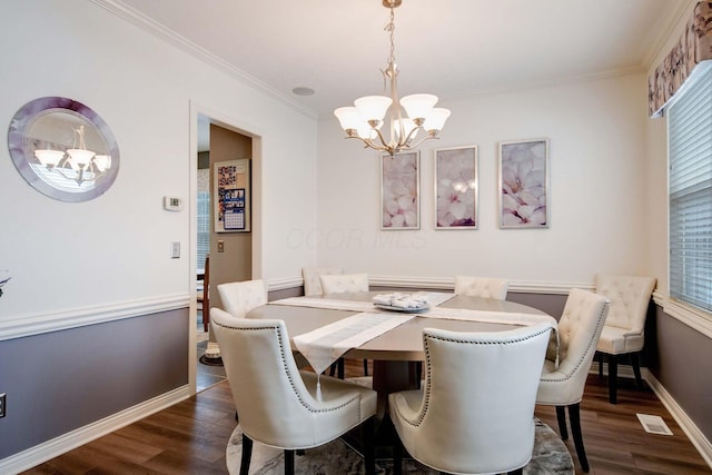 dining space featuring crown molding, dark hardwood / wood-style floors, and a chandelier