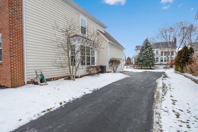 view of snow covered exterior featuring central AC unit