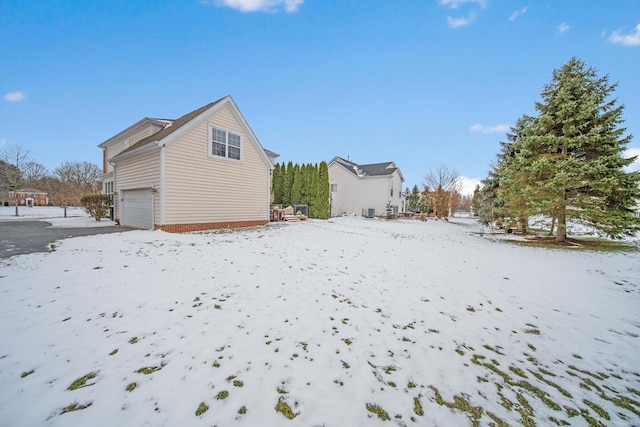 snow covered back of property with a garage