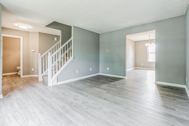 empty room featuring hardwood / wood-style floors and an inviting chandelier