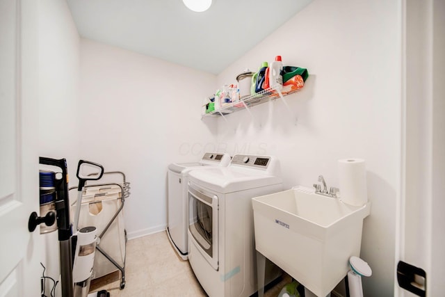 clothes washing area with washing machine and clothes dryer and sink