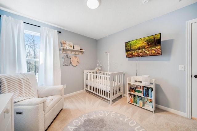 bedroom featuring a crib and light colored carpet