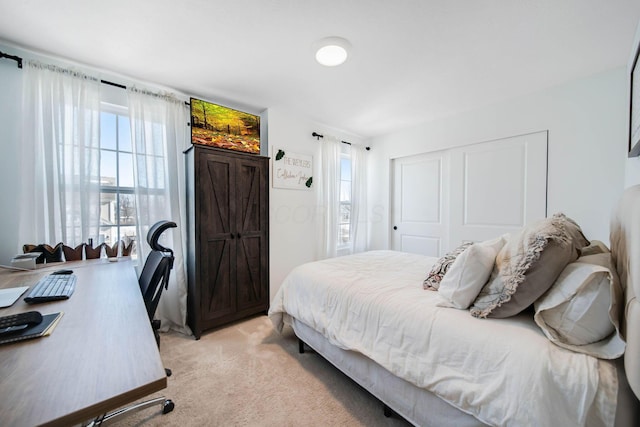 bedroom featuring light carpet and a closet