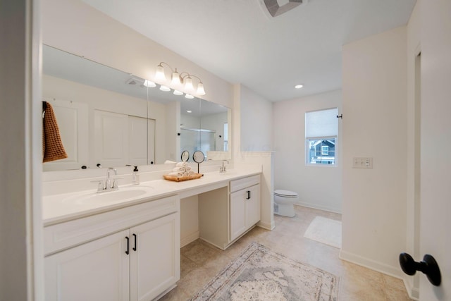 bathroom with vanity, toilet, and a shower with door