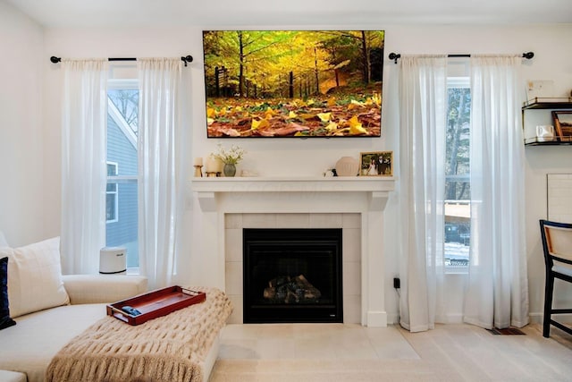 living area with light colored carpet, a healthy amount of sunlight, and a fireplace