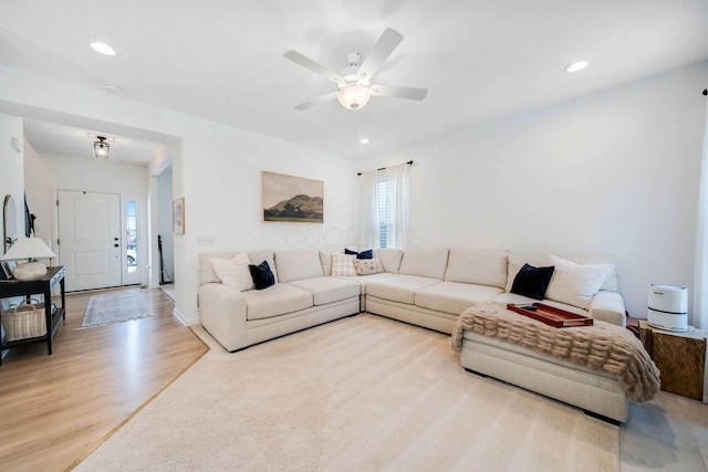 living room with ceiling fan and light hardwood / wood-style flooring