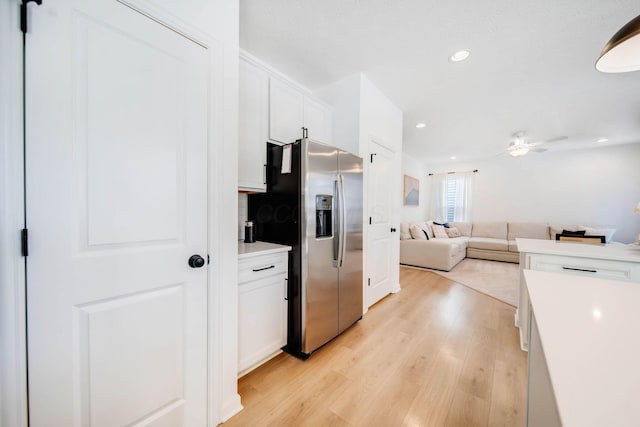 kitchen featuring ceiling fan, stainless steel fridge, light hardwood / wood-style floors, and white cabinets