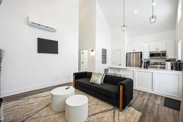 living room featuring high vaulted ceiling, sink, dark hardwood / wood-style floors, and a wall mounted air conditioner