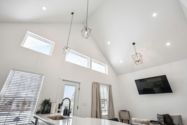 interior space featuring lofted ceiling, sink, and pendant lighting