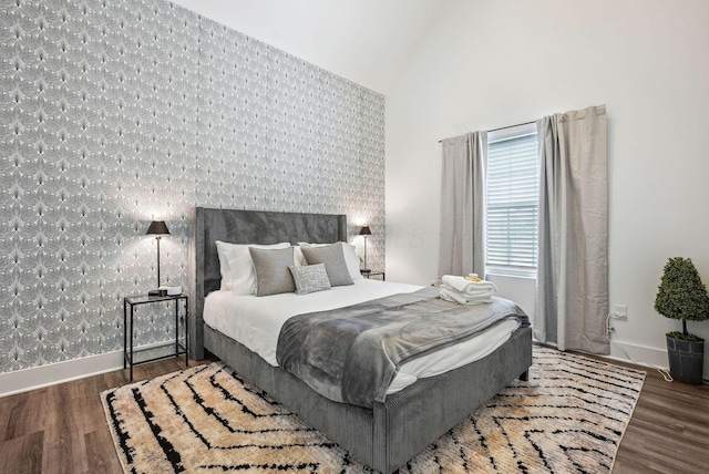 bedroom with dark wood-type flooring and a towering ceiling