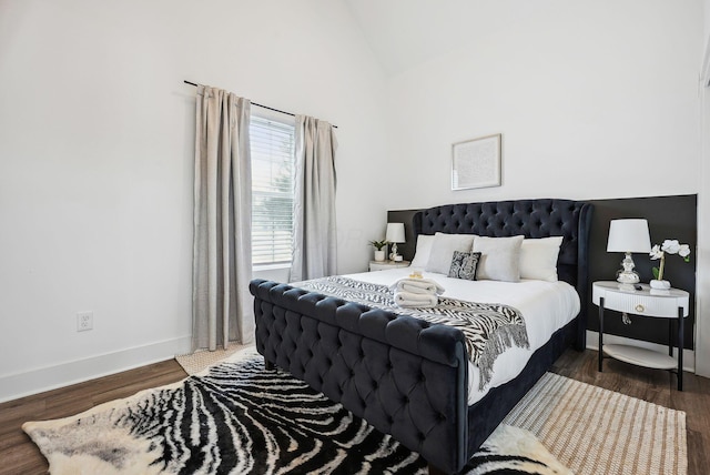 bedroom featuring dark wood-type flooring and high vaulted ceiling