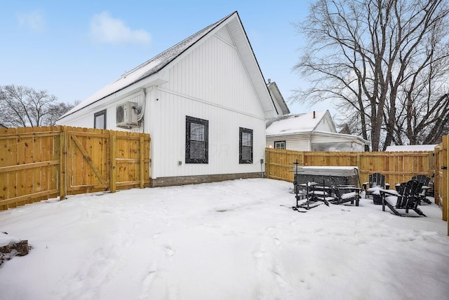 snow covered house with ac unit and a hot tub