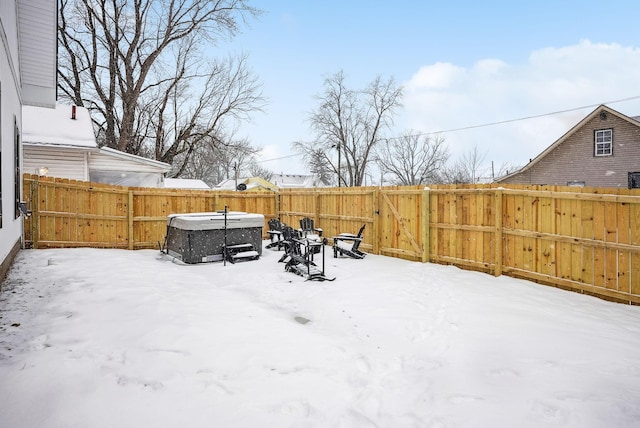 yard layered in snow featuring a hot tub