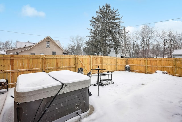 yard covered in snow featuring a hot tub