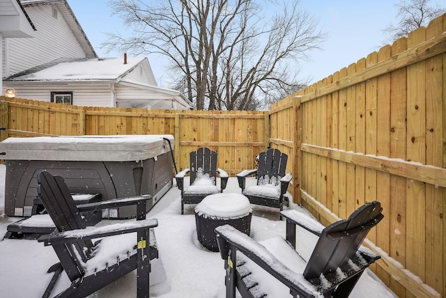 snow covered patio featuring a hot tub