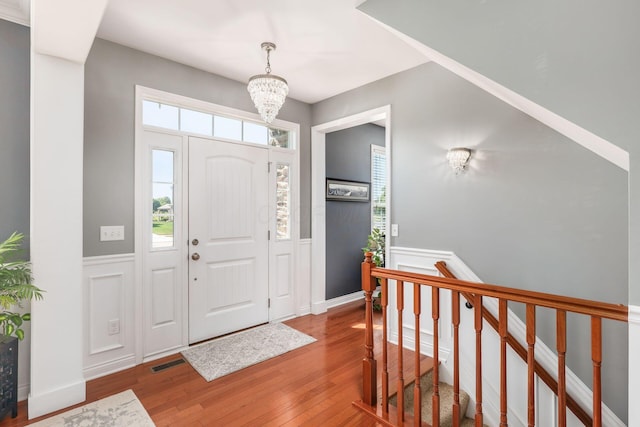 entrance foyer featuring wood-type flooring and an inviting chandelier