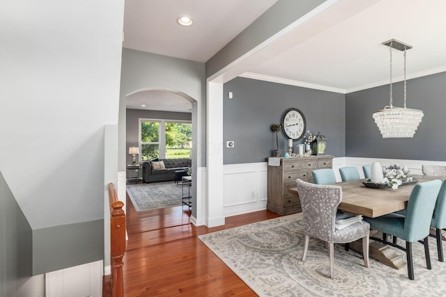 dining space featuring a chandelier, wood-type flooring, and ornamental molding