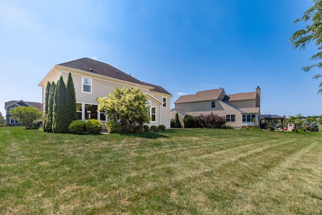 rear view of property with a lawn